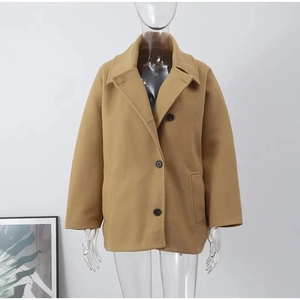 Détail de la veste en laine camel à boutonnage simple avec col à revers et poches
