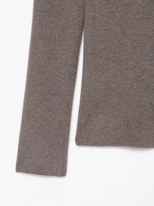 Detailed close-up of brown knit fabric showing soft texture and ribbed cuffs