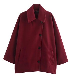 Détail d'une veste en laine bordeaux avec col à revers, boutons et étiquette de taille