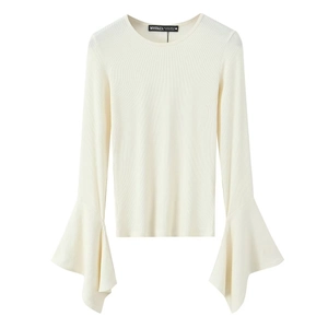 Detail of bell sleeves and ribbed texture on an off-white long sleeve knit top