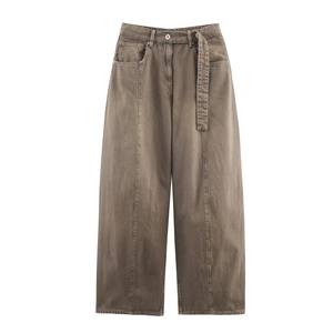 Detail of vintage brown wide-leg jeans featuring front seams and matching belted waist