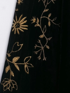 Detail der schwarzen Samtjacke mit aufwendiger goldener Blumenstickerei und Sonnenblumen