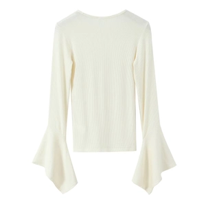 Detail of white ribbed knit long sleeve top featuring elegant flared ruffle cuffs