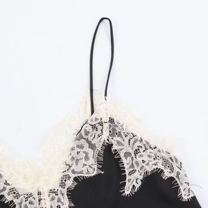 Close-up of contrast eyelash lace trim on a black satin camisole top with thin straps