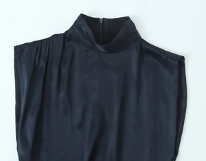 Detailed view of dark satin mini dress featuring pleated neckline and hidden back zipper