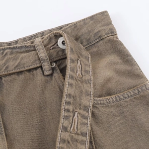 Detailed macro view of khaki denim waist showing metal button and reinforced stitching