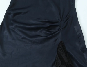 Detail of black satin dress with side ruching and elegant lace trim stitching