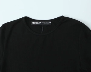 Detail of crew neck collar with brand tag on black ribbed long sleeve T-shirt