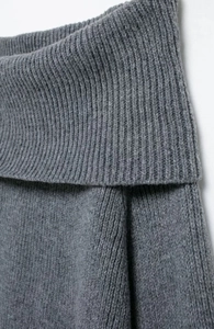 Detaillierte Makroansicht des weichen grauen Strickstoffs und des schulterfreien Designs