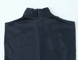 Detail of high neck satin mini dress featuring a concealed back zipper and glossy fabric