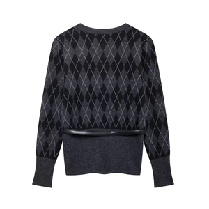 Detail of grey diamond pattern knitted cardigan with black belt and ribbed cuffs
