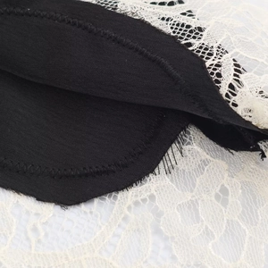 Close-up of contrast lace stitching and satin fabric texture on the backless top
