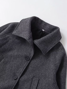 Détail d'un manteau court en laine gris foncé avec revers et fermeture à boutons