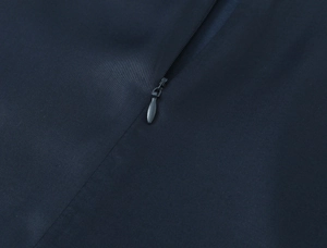 Detail of invisible teardrop zipper on dark blue lace satin mini dress fabric