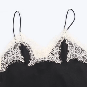 Close-up of black satin camisole featuring white eyelash lace trim and thin straps