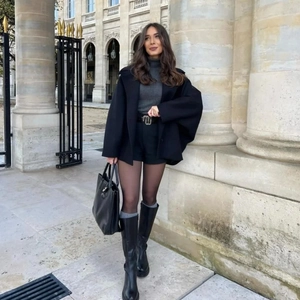 Veste chic en laine pour femme avec bottes hautes dans un décor de rue européen classique