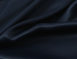 Macro shot of high-quality navy satin fabric with smooth texture and elegant luster