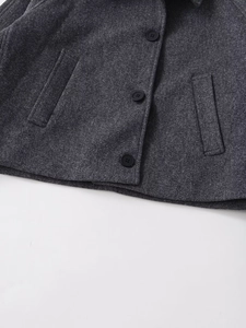 Détail de la veste en laine gris foncé avec boutons ronds et poches verticales