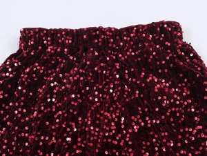 Détail macro du tissu velours à paillettes bordeaux et de la taille haute élastique