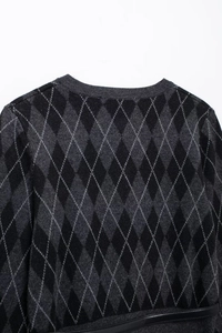 Close-up of diamond argyle knit sweater with ribbed crew neck and leather trim detail
