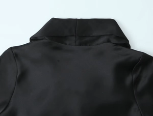 Detailaufnahme der schwarzen Satin-Textur und der hochwertigen Kragennaht am Minikleid