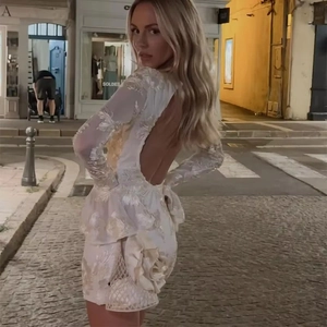 Détail de la mini robe en dentelle blanche avec dos nu et broderie florale 3D