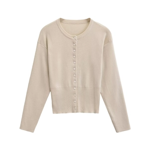 Detail of beige knit cardigan featuring a round neck and ribbed hem texture