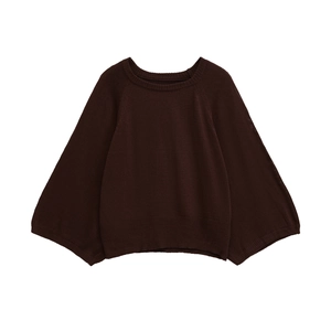 Detail of dark brown knit sweater showing the fine texture and ribbed cuff design