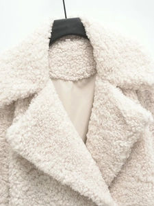 Détail du manteau en fausse fourrure beige avec texture sherpa douce et doublure de qualité