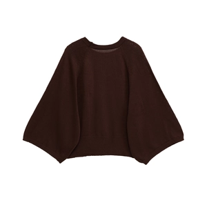 Close-up of dark brown knit sweater with loose batwing sleeves and ribbed hem texture