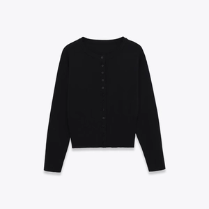 Detail of black knit cardigan showing ribbed cuffs, round neck, and fine texture