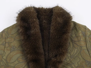 Gros plan sur un manteau vert olive avec col en fausse fourrure et broderie paisley
