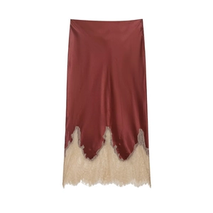 Close-up of elegant burgundy satin skirt with delicate beige lace hem and wavy lace details