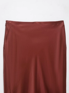 Detail view of the side invisible zipper and smooth satin fabric on this burgundy skirt