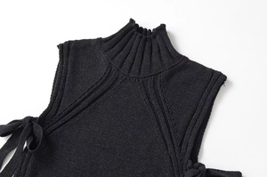Detalle de un top de punto sin mangas negro con cuello alto y texturas acanaladas