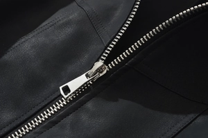 Macro detail of high-quality silver metal zipper on a black leather bomber jacket