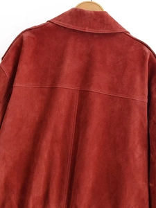 Dettaglio posteriore della giacca in finta pelle bordeaux con cuciture e trama del tessuto