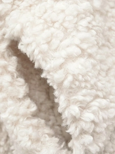 Gros plan macro de la texture douce en fausse laine d'agneau blanche pour manteau