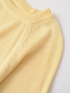 Close-up of the ribbed crew neck and fine knit texture of this light yellow autumn sweater