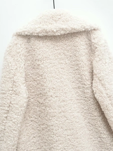 Détail macro du manteau en fausse fourrure blanche avec texture peluche et large col