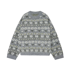 Close-up of Fair Isle snowflake pattern on thick grey knit sweater with ribbed neckline