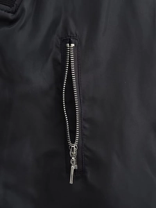 Detail of silver metal zipper on high-density black nylon jacket fabric with ribbed texture