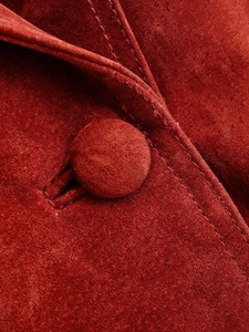 Dettaglio del tessuto scamosciato rosso con bottone rivestito e cuciture di alta qualità