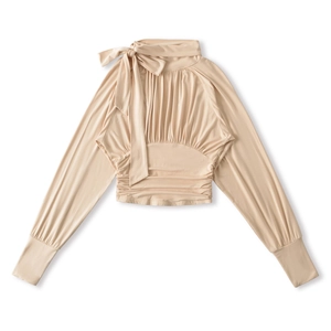Detail of elegant apricot long sleeve blouse featuring bow tie neck and pleated chest