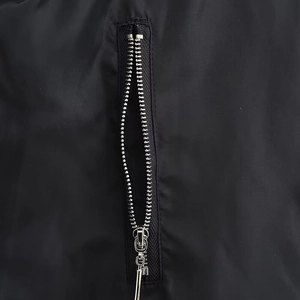 Detailed close-up of premium silver metal zipper on a black fashion winter jacket