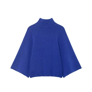 Detail of royal blue high-neck sweater showing the soft wool texture and wide sleeves