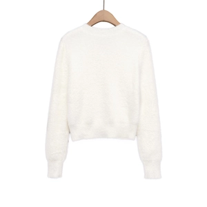 Detail of soft white mohair knit sweater featuring round neck and ribbed cuffs on a hanger