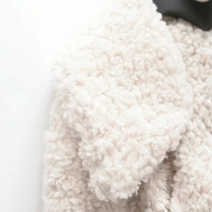 Manteau blanc en fausse fourrure d'agneau avec col à revers et texture bouclée douce