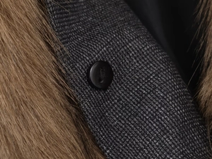 Détail macro d'un col en fausse fourrure et d'un tissu en laine texturé avec bouton noir