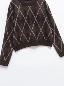 Detailed close-up of dark brown argyle knit sweater with round neck and ribbed edges